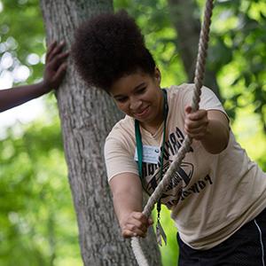 Student grabs a rope on the ropes course