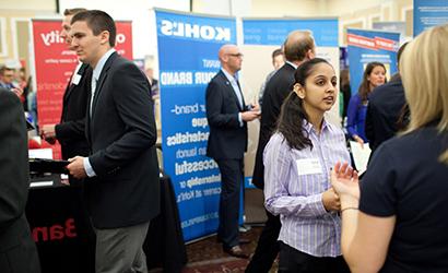 Students talk to each other during a career fair.